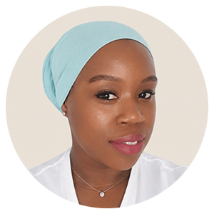Smiling woman wearing a light blue headscarf and a white top, promoting inclusive wellbeing support.
