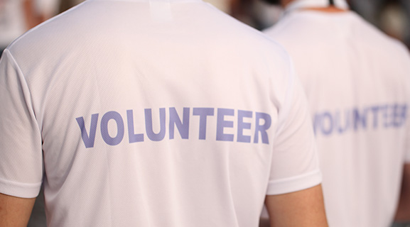 Volunteers wearing white shirts with the word